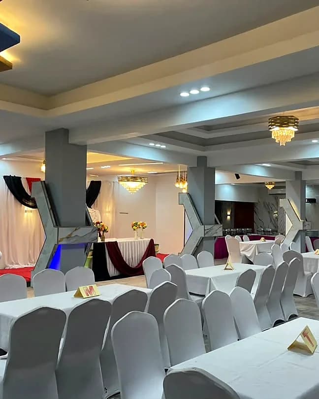 Vue générale de la salle polyvalente, table d’honneur et lustres